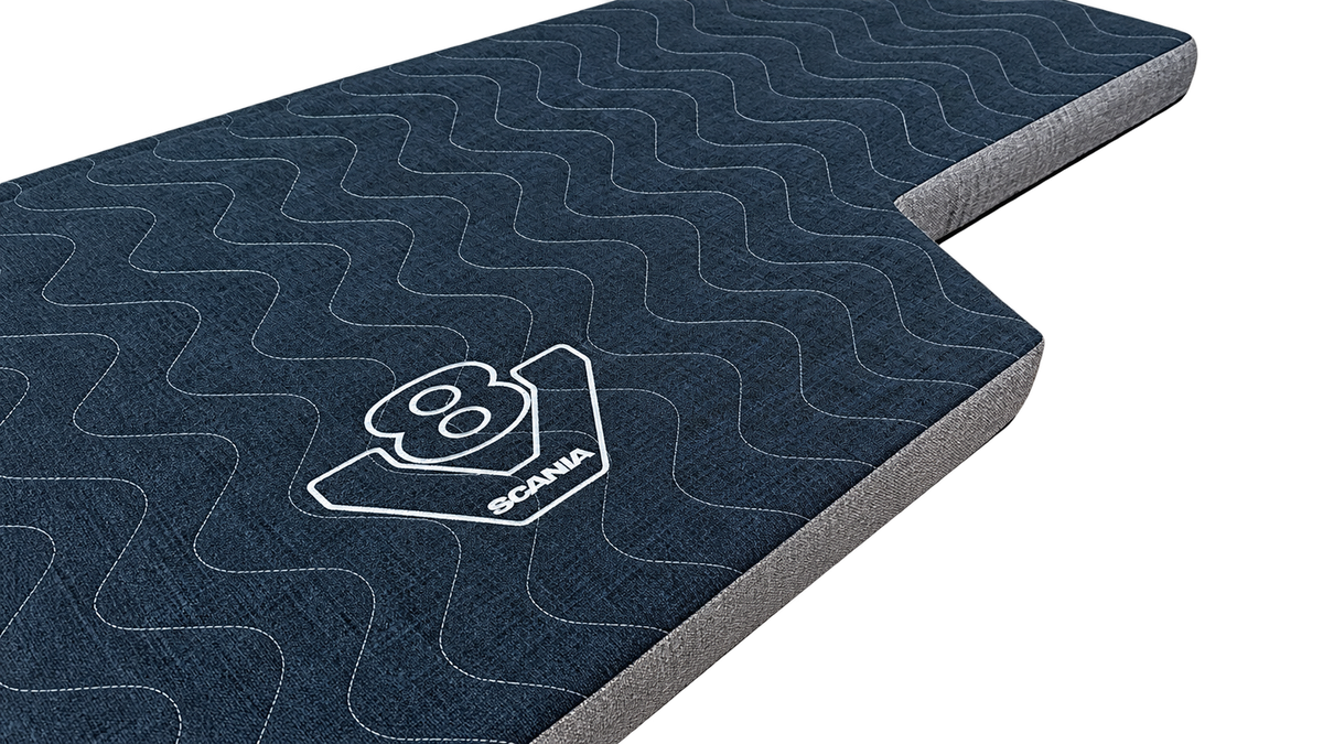 Scania Next Gen V8 pull-out bed mattress topper, showing its dark quilted fabric, shaped edge and Scania V8 logo